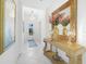 Bright hallway featuring a decorative table with mirror and chandelier, and tiled floors at 11383 Burgundy Dr, Venice, FL 34293