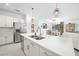 Bright open kitchen featuring a large island, stainless appliances, quartz countertops and elegant pendant lighting at 11383 Burgundy Dr, Venice, FL 34293