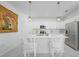 Modern kitchen with white cabinets, quartz countertops, stainless steel appliances, and an island with seating at 11383 Burgundy Dr, Venice, FL 34293