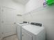 Clean laundry room equipped with new washer and dryer units, storage shelves, and bright lighting at 11383 Burgundy Dr, Venice, FL 34293