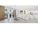 Bright living room with white furniture, tiled floors, and sliding glass doors leading to a covered patio at 11383 Burgundy Dr, Venice, FL 34293