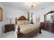 Opulent main bedroom with a decorative chandelier, classic furnishings, and access to the ensuite bathroom at 11383 Burgundy Dr, Venice, FL 34293
