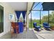Enjoy views from the lanai that includes a table with chairs, comfortable seating, and decorative curtains at 11383 Burgundy Dr, Venice, FL 34293