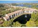 Scenic aerial view of the condo complex with a pond and fountain amidst lush greenery, showcasing waterfront living at 1144 Bird Bay Way # 102, Venice, FL 34285