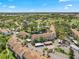 Aerial view of condos surrounding a pond, showcasing lush landscaping, green fairways and community at 1144 Bird Bay Way # 102, Venice, FL 34285