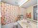 The bathroom has a vanity and a shower/tub combo, complemented by a bright floral curtain at 1144 Bird Bay Way # 102, Venice, FL 34285