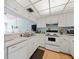 Well-lit kitchen featuring white appliances, ample cabinet space, and an open design at 1144 Bird Bay Way # 102, Venice, FL 34285