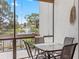 Enclosed lanai with a glass table set offers a peaceful view of the pond and fountain at 1144 Bird Bay Way # 102, Venice, FL 34285
