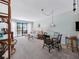 Cozy living room with a glass dining table, sliding glass door to a private outdoor seating area at 1144 Bird Bay Way # 102, Venice, FL 34285
