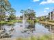 A picturesque pond with a fountain offers a peaceful focal point for the community at 1144 Bird Bay Way # 102, Venice, FL 34285