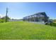 Spacious backyard highlighting a screened-in pool and ample green space at 12112 Helios Ave, Port Charlotte, FL 33981