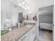 Bright bathroom featuring a granite countertop vanity, and a view into a bedroom at 12112 Helios Ave, Port Charlotte, FL 33981