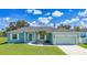 Charming single-story home featuring a well-manicured lawn and an attached two-car garage at 12112 Helios Ave, Port Charlotte, FL 33981
