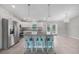 Modern kitchen with stainless steel appliances, granite countertops, white cabinets, and stylish bar stools at 12112 Helios Ave, Port Charlotte, FL 33981