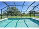 Sparkling screened-in pool with bright, clear water, surrounded by lush greenery at 12112 Helios Ave, Port Charlotte, FL 33981
