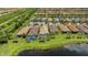 An aerial view of multiple neighborhood homes, many of which have pools, near a scenic lake at 13935 Campoleone St, Venice, FL 34293