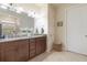Bathroom with double sink granite vanity, decorative mirror, and ceramic floors at 13935 Campoleone St, Venice, FL 34293