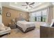 Cozy bedroom with a ceiling fan, neutral decor and large window at 13935 Campoleone St, Venice, FL 34293