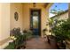 Inviting front entryway with a decorative door, brick pavers, and potted plants at 13935 Campoleone St, Venice, FL 34293