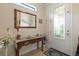Entryway featuring tile floors, console table with floral arrangement, and decorative mirror at 13935 Campoleone St, Venice, FL 34293