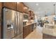 Open kitchen with stainless steel refrigerator, granite countertops, and easy access to dining and living areas at 13935 Campoleone St, Venice, FL 34293