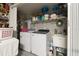 Efficient laundry room with modern appliances, ample shelving, and a convenient utility sink at 13935 Campoleone St, Venice, FL 34293