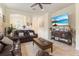 Cozy living room featuring comfortable leather seating, a ceiling fan, and a large TV at 13935 Campoleone St, Venice, FL 34293