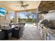 Luxurious outdoor kitchen and dining area with pool views, ideal for entertaining and enjoying the outdoors at 13935 Campoleone St, Venice, FL 34293