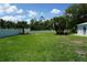 Expansive backyard with lush green grass and a white picket fence, creating a private outdoor space at 15037 Mcgraw Ave, Port Charlotte, FL 33953