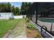 Backyard featuring a screened-in pool, shed, manicured lawn, and mature landscaping at 15037 Mcgraw Ave, Port Charlotte, FL 33953