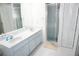 Bright bathroom featuring a double sink vanity and a glass-enclosed shower at 15037 Mcgraw Ave, Port Charlotte, FL 33953