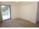 Bedroom with neutral carpet, closet, and screened backyard access at 15037 Mcgraw Ave, Port Charlotte, FL 33953