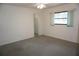 Bedroom with neutral carpet, ceiling fan, window with blinds, and closet access at 15037 Mcgraw Ave, Port Charlotte, FL 33953