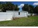 Exterior view of a well-maintained shed with white siding, nestled in the green backyard at 15037 Mcgraw Ave, Port Charlotte, FL 33953