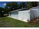 Side view of the white shed with a hose, showcasing its clean design and practicality in the backyard at 15037 Mcgraw Ave, Port Charlotte, FL 33953