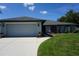 Exterior view showcasing the home's manicured lawn, garage, and artistic features at 15037 Mcgraw Ave, Port Charlotte, FL 33953