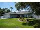 Charming single-story home featuring a well-manicured lawn, a two car garage, and fountain at 15037 Mcgraw Ave, Port Charlotte, FL 33953