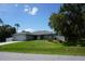 Charming single-story home with a well-manicured lawn, mature trees, and a two car garage at 15037 Mcgraw Ave, Port Charlotte, FL 33953