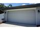 Oversized garage door showing an attached two car garage, complete with exterior sconces at 15037 Mcgraw Ave, Port Charlotte, FL 33953