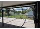 View of the backyard from inside the screened lanai, featuring a brick paver floor at 15037 Mcgraw Ave, Port Charlotte, FL 33953