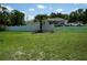 Well-maintained yard with lush grass and a white fence surrounding the property at 15037 Mcgraw Ave, Port Charlotte, FL 33953