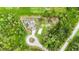 Aerial image showcasing the house with a screened-in pool surrounded by lush greenery at 1546 Gourmet Rd, North Port, FL 34288