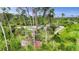 Backyard view of the house with a surrounding of many green trees and bushes at 1546 Gourmet Rd, North Port, FL 34288