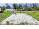 Large backyard area with shell base and defined border, surrounded by mature trees and lush greenery at 1546 Gourmet Rd, North Port, FL 34288