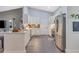 Well-lit kitchen features white cabinets, stainless steel appliances, and an open layout with gray tile floors at 1546 Gourmet Rd, North Port, FL 34288