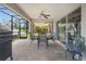 Relaxing screened patio featuring tile flooring, outdoor dining set, and ceiling fan at 1546 Gourmet Rd, North Port, FL 34288