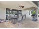Cozy screened-in patio with tile flooring, ceiling fan, and comfortable outdoor seating at 1546 Gourmet Rd, North Port, FL 34288