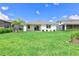 The spacious backyard features lush green grass and a view of the back of the house with its covered patio at 16336 Preservation Blvd, Punta Gorda, FL 33982