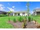 Beautiful backyard featuring green grass, landscaping and a view of the rear exterior of the home at 16336 Preservation Blvd, Punta Gorda, FL 33982