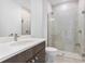 Modern bathroom features a glass enclosed shower, neutral tiles, and a spacious vanity with sleek fixtures at 16336 Preservation Blvd, Punta Gorda, FL 33982